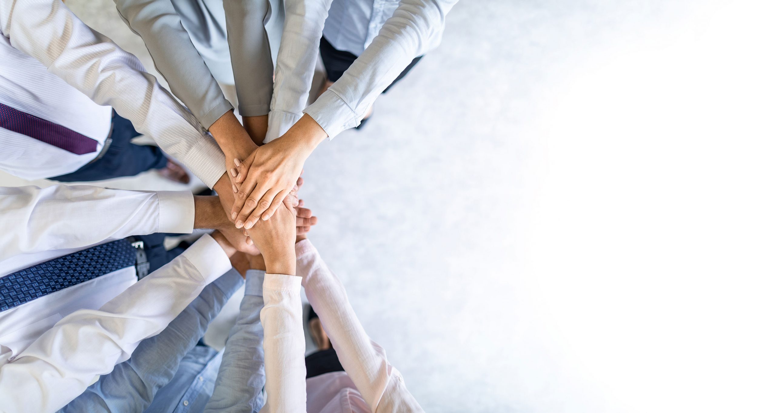 A closeup of employees stacking hands in a team-building fashion