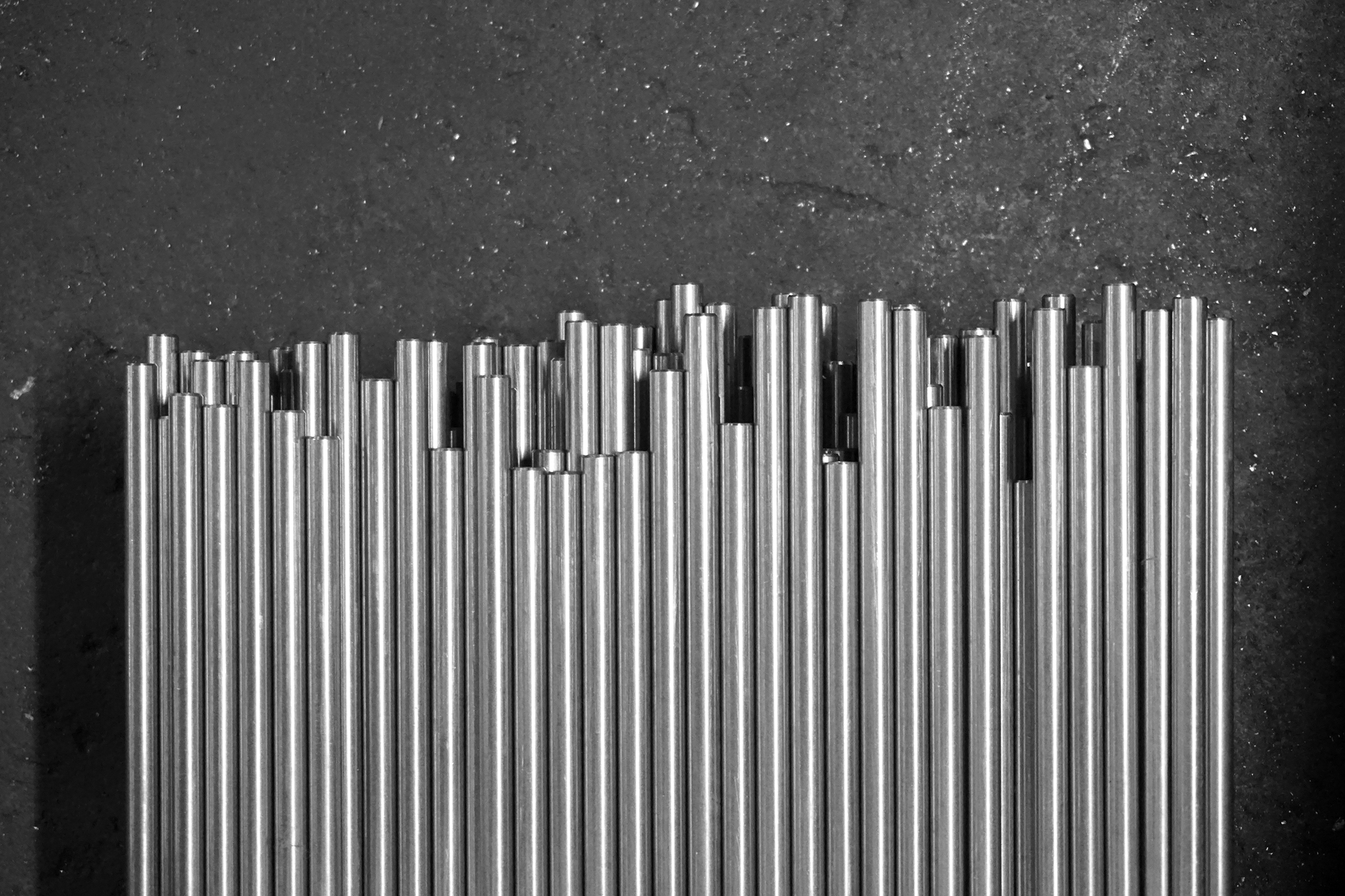 Several stacks of metal rods laying on concrete